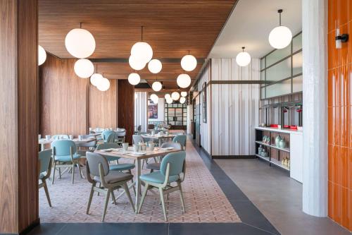 a dining room with tables and chairs and lights at Best Western Premier Malta in St Paul's Bay