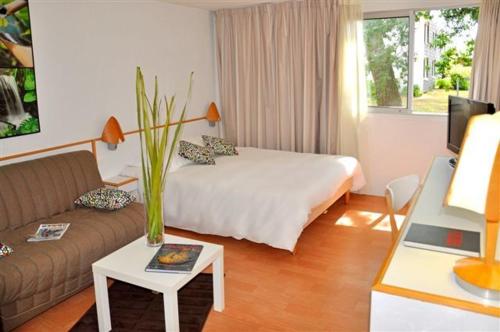 a hotel room with a bed and a couch at Lorient Résidence in Caudan