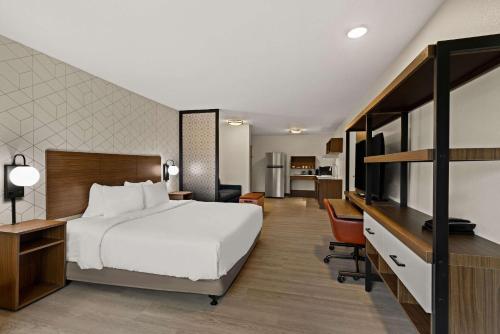 um quarto de hotel com uma cama grande e uma secretária em Everhome Suites Chandler Phoenix Fashion Center em Chandler