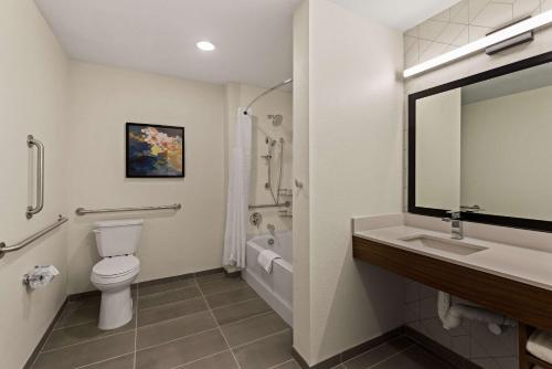 uma casa de banho com um WC, um lavatório e um espelho. em Everhome Suites Chandler Phoenix Fashion Center em Chandler
