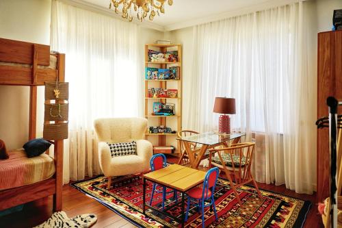 a living room with a table and a chair at Villa Vermont Qusar in Qusar