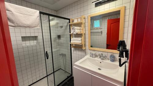 een badkamer met een douche, een wastafel en een spiegel bij Aliş Boutique Hotel in Canakkale