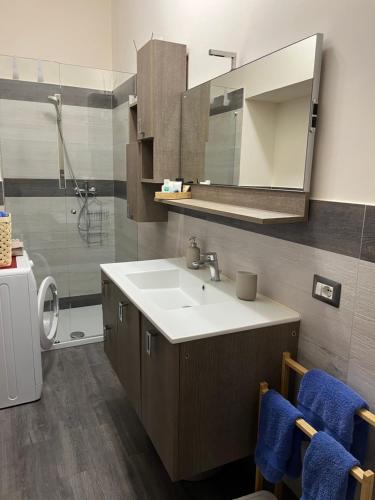 ein Bad mit einem Waschbecken, einem Spiegel und einer Dusche in der Unterkunft Casa Pont1 in Scala