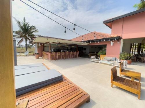 a patio with a wooden bench and a house at Arrue Coastal Escape at Andromeda Pedasi in Loma del Naranjo