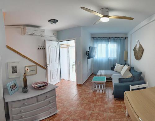 Una sala de estar con un sofá azul y una mesa. en Casa Mellis Aguamarga, en Agua Amarga