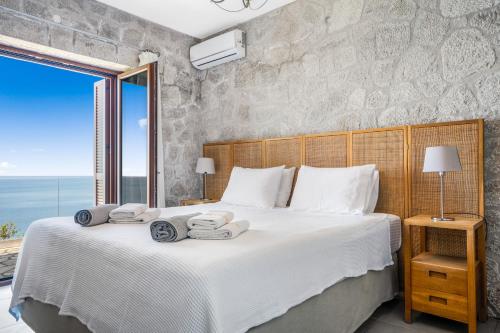 a bedroom with a large bed with towels on it at Milos Paradise Luxury Villas in Agios Nikitas