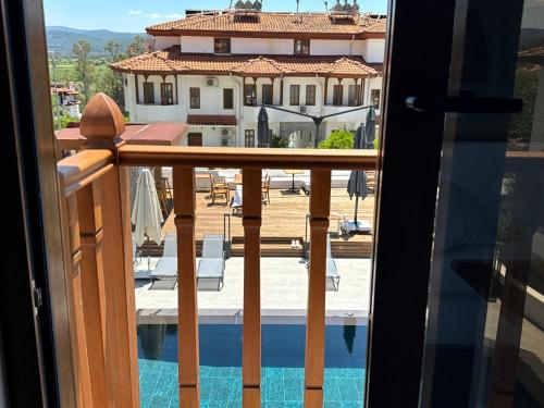 a balcony with a view of a pool and a house at Tomsan Suites & Villas Akyaka in Akyaka