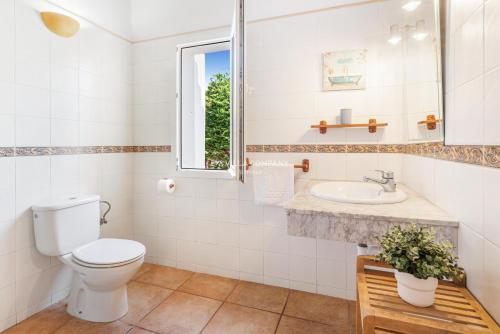 a bathroom with a toilet and a sink at Villa CASSIA in Cala'n Porter