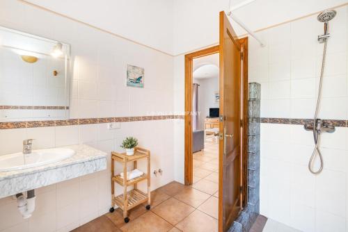 a bathroom with a sink and a shower at Villa CASSIA in Cala'n Porter