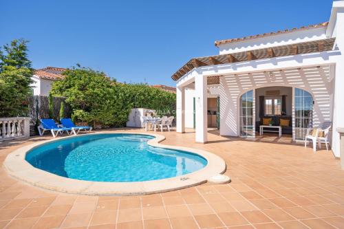 a swimming pool in a yard with a gazebo at Villa CASSIA in Cala en Porter