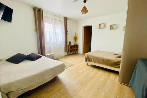 a bedroom with two beds and a large window at Joli Appartement Proche Plage in Ahetze
