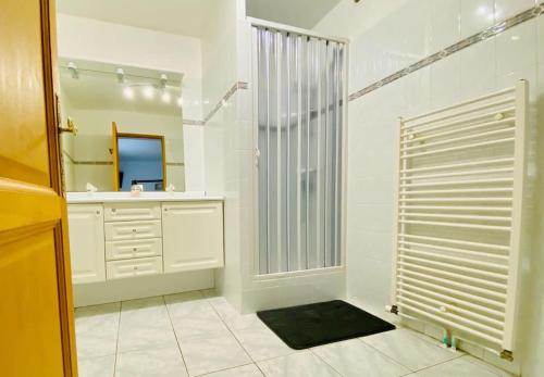 W łazience znajduje się prysznic, umywalka i lustro. w obiekcie Joli Appartement Proche Plage w mieście Ahetze