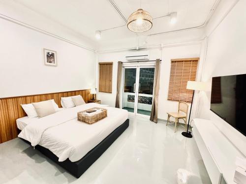 a bedroom with a large bed and a tv at Momento Hotel and Cafe in Khon Kaen