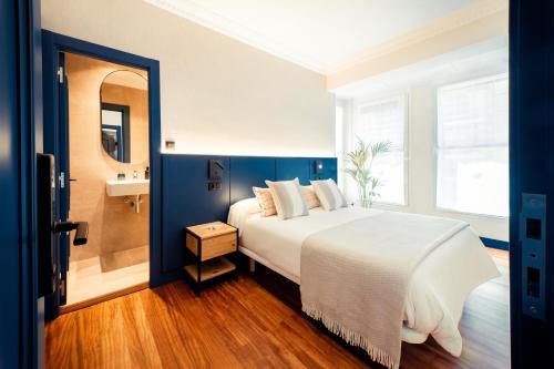 1 dormitorio con 1 cama grande y espejo en GETXO ROOMS, en Getxo