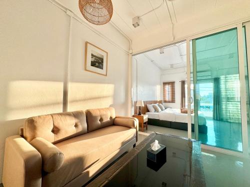 a living room with a couch and a bed at Momento Hotel and Cafe in Khon Kaen
