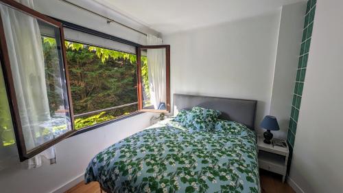 ヌイイ・シュル・セーヌにあるAdorable apartment in posh Neuillyのベッドと大きな窓のある寝室