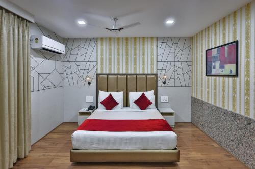 a bedroom with a large bed with red pillows at Hotel Cama in Chandīgarh