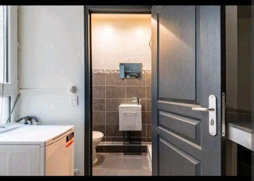 La salle de bains est pourvue d'une porte, de toilettes et d'un lavabo. dans l'établissement Charmant studio au cœur de Montelimar, à Montélimar
