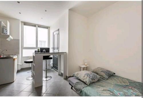 une chambre avec un lit et un bureau dans l'établissement Charmant studio au cœur de Montelimar, à Montélimar