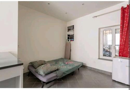 une chambre avec un lit et une fenêtre dans l'établissement Charmant studio au cœur de Montelimar, à Montélimar