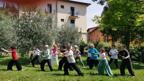 a group of people dancing in the grass at Ostello delle cartiere in Toscolano Maderno