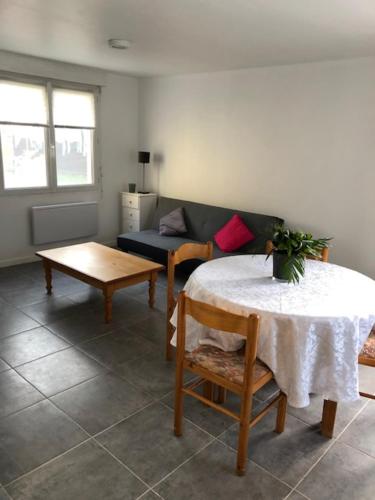 un salon avec une table et un canapé dans l'établissement Logement T2 avec terrasse idéal Loire à vélo, à Saint-Brévin-les-Pins
