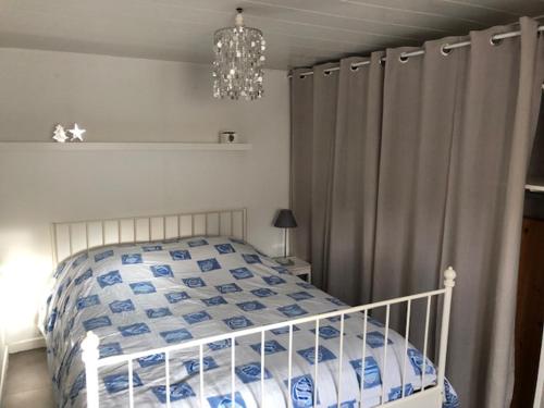a bedroom with a bed with a blue and white comforter at LA PECHERIE in Saint-Brevin-les-Pins