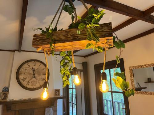 a hanging pendant light with lights and a clock at Retour aux Sources in Hastière-par-delà
