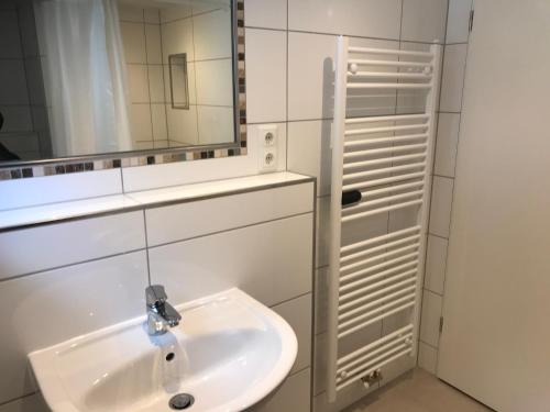 ein Badezimmer mit Waschbecken und Spiegel in der Unterkunft Zimmerding in Erding