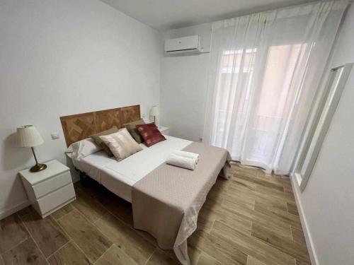 Un dormitorio con una cama grande y una ventana en Apartamenticos Libertad I, en Zaragoza