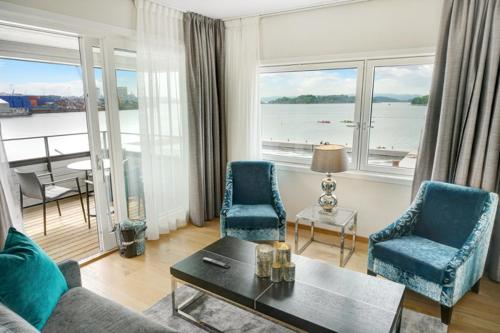 sala de estar con sofá, sillas y mesa en Wright Apartments - Sørenga en Oslo