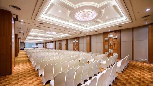 a large room with white chairs and a ceiling at ST Vegas Hotel in Ban Nong-Heo