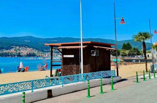 a small building on a beach next to the water at Apartamento Exclusivo a pie de Playa in Vigo