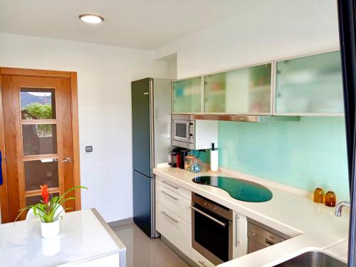 a kitchen with a sink and a refrigerator at Apartamento Exclusivo a pie de Playa in Vigo