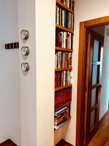 a book shelf filled with books next to a door at Apartamento Exclusivo a pie de Playa in Vigo