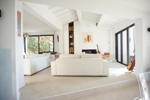 - un salon blanc avec des meubles et des fenêtres blancs dans l'établissement VILLA ROUTE DE RAMATUELLE, à La Croix-Valmer