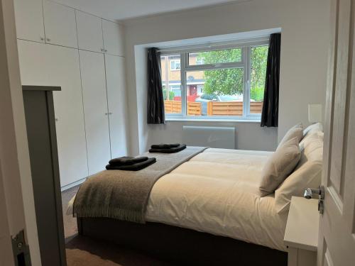 Schlafzimmer mit einem Bett und einem Fenster in der Unterkunft Spacious self-contained flat - 33AS1 in London