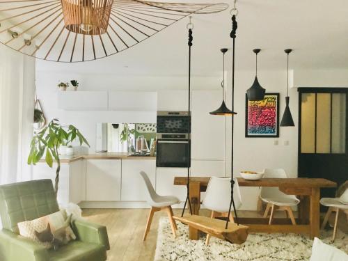 une cuisine et un salon avec une table et des chaises dans l'établissement Hygge Loft Nantes Gare TGV jardin des plantes, à Nantes
