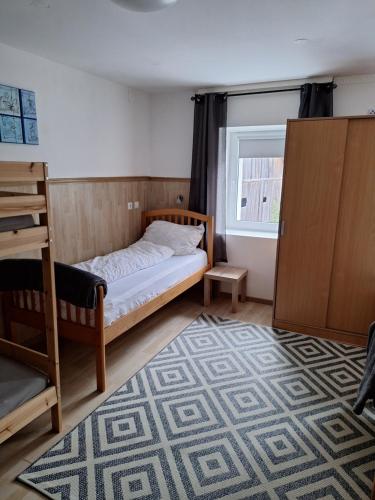 - une chambre avec un lit, une fenêtre et un tapis dans l'établissement Zirnberg Appartements, à Flattach