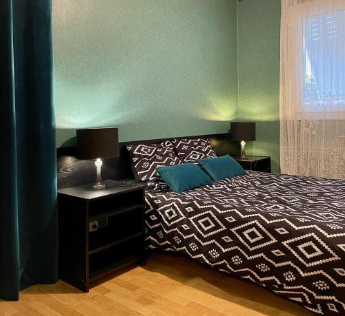 a bedroom with a bed and two lamps and a window at Cosy apartment proche Paris et Disneyland in Gagny