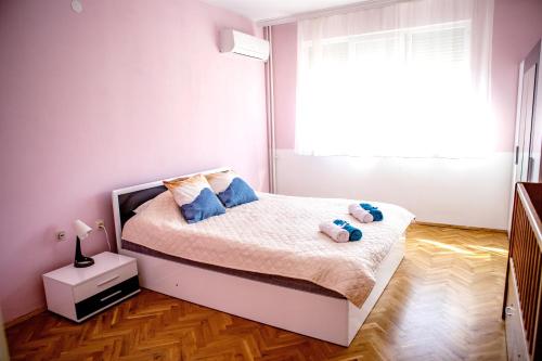 a bedroom with a bed with two stuffed animals on it at Rozina by RV Apartments in Kazanlŭk