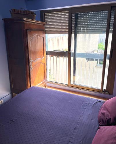 une chambre avec un lit et une grande fenêtre dans l'établissement Chambre d'hôtes au calme, à Paris