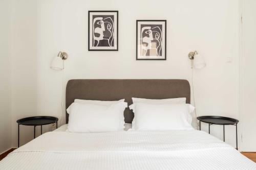een slaapkamer met een wit bed en 2 tafels bij YestayHomes * Kolonaki * Tsakalof Street in Athene