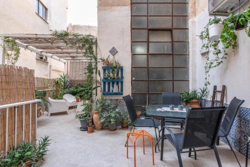 une terrasse avec une table, des chaises et des plantes dans l'établissement Sant'Agostino Apartment with Terrace by Wonderful Italy, à Palerme