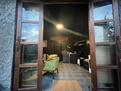 an open door to a room with a chair at KUBU BLACK HOUSE in Jembrana