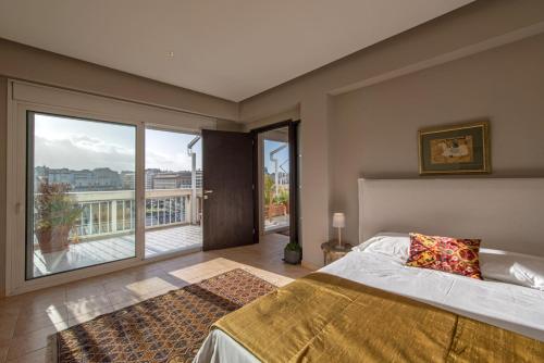 um quarto com uma cama grande e uma janela grande em Holodek Apartments Ippokratous em Atenas
