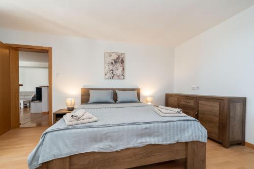 a bedroom with a large bed with two towels on it at Ema's Olive Garden Apt 2 -private parking, 10 min drive from sandy beach in Poličnik