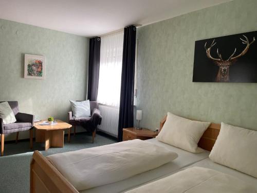 a hotel room with a bed and a table and chair at Gasthof zur Burgruine in Pottenstein