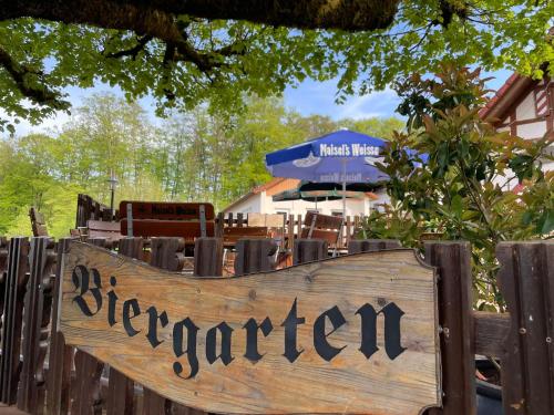 a wooden sign for a restaurant on a fence at Gasthof zur Burgruine in Pottenstein
