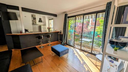 un salon avec une grande fenêtre et une table dans l'établissement Adorable apartment in posh Neuilly, à Neuilly-sur-Seine